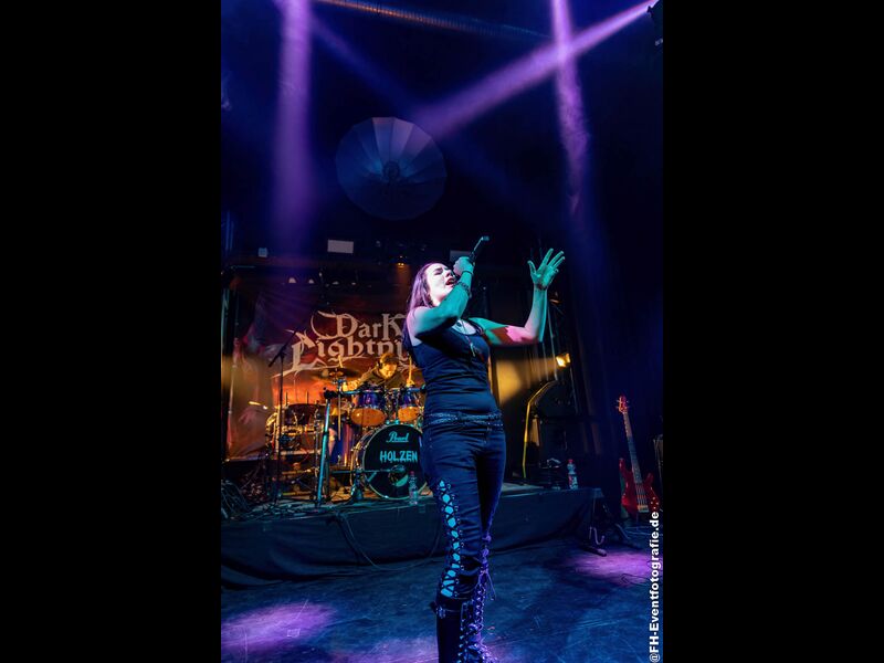 Dark Lightning live, vocals in front of the band banner, 30th September 2022. Photo: FH-Eventfotografie